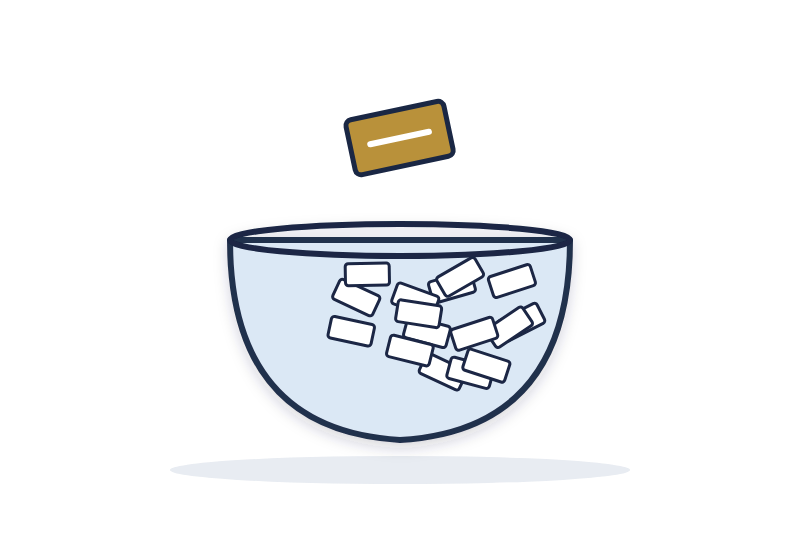 a glass bowl filled with folded paper slips, with one gold slip held above it